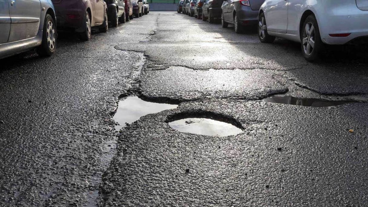 Nids-de-poule sur une ruelle. 
