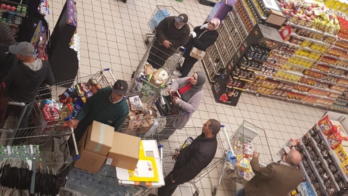 Des clients aux caddies remplis font la queue à la caisse d'une grande surface, au Maroc. 
