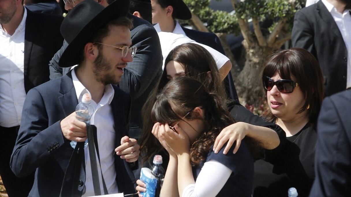 Une femme juive ultra-orthodoxe en réconforte une autre dans un cimetière de Benei Brak, alors qu'ont lieu les funérailles de l'une des victimes de la bousculade, lors de la fête de Lag Baomer sur le mont Méron, dans le nord d'Israël, au soir du 30 avril 2021. Bilan: 45 morts. 
