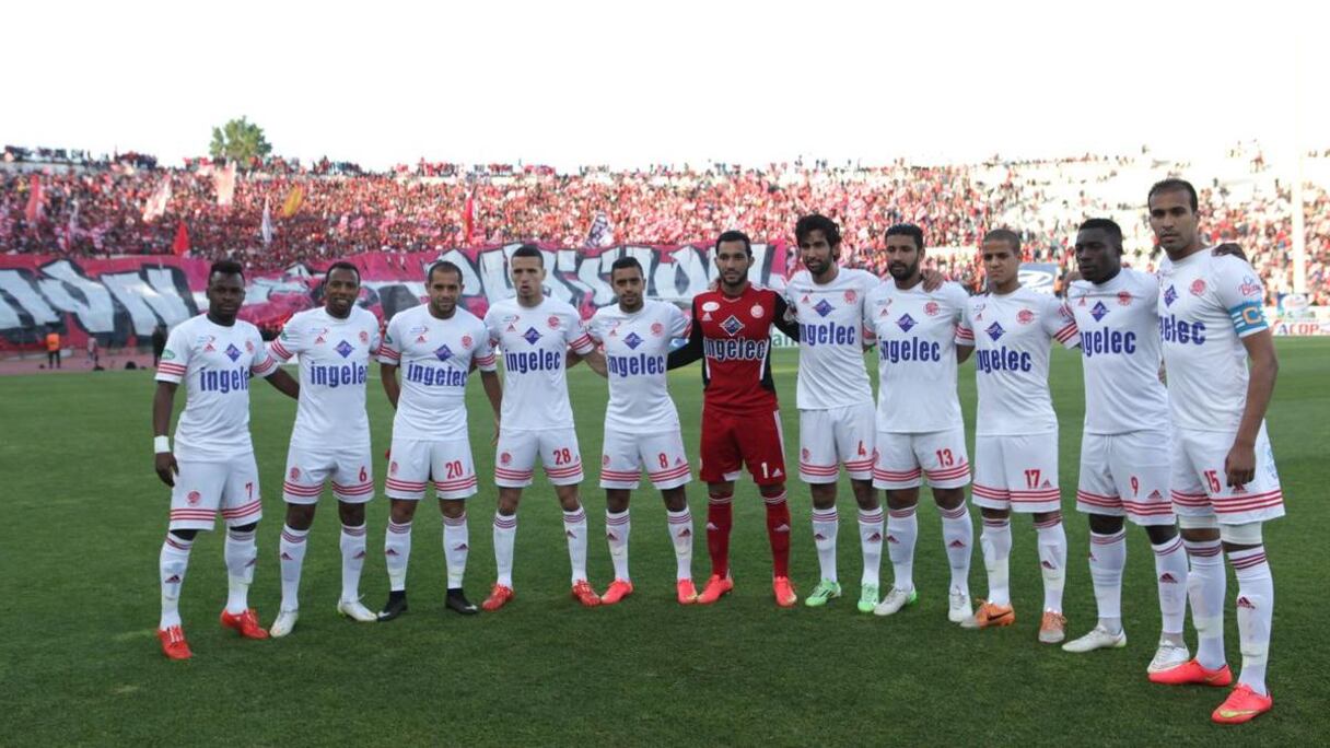 Le onze de départ pause devant le tifo de leurs supporters. 
