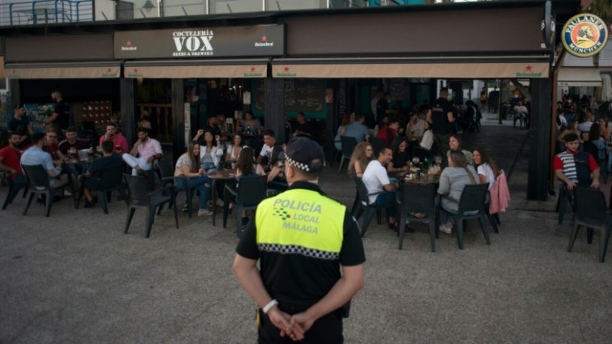 Un policier surveille le respect de consignes anticoronavirus dans un restaurant de Malaga le 23 mai 2020.
