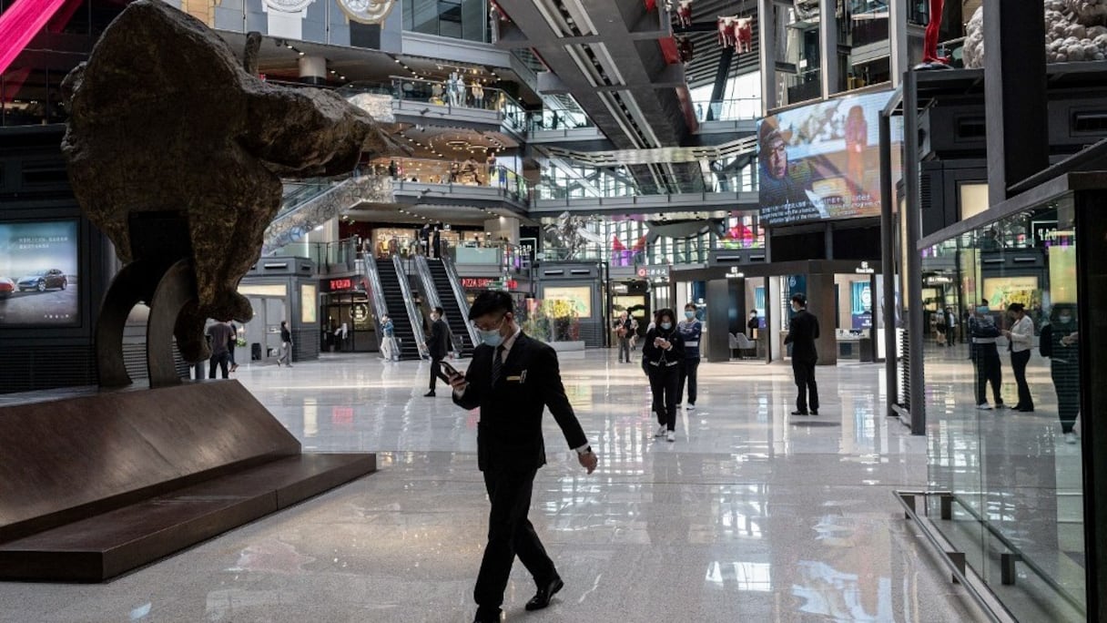 Des personnes marchent à l'intérieur d'un centre commercial à l'heure du déjeuner, à Pékin, le 14 avril 2021.
