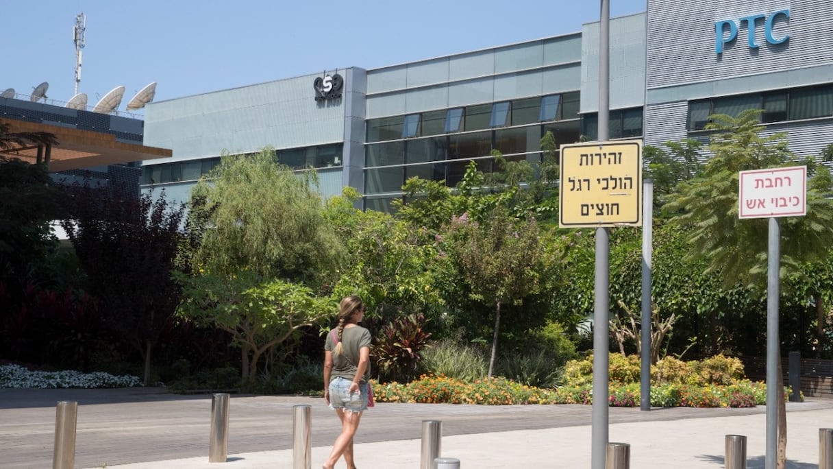 Une femme marche devant le bâtiment abritant le groupe israélien NSO, à Herzliya, près de Tel Aviv. L'entreprise israélienne est accusée par plusieurs médias de fournir des logiciels espions à des gouvernements, dont le Maroc. 
