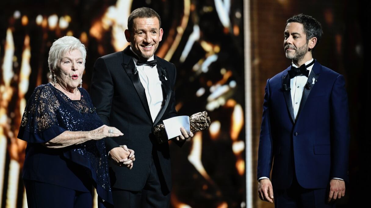 Danny Boon, accompagné de Line Renaud et Manu Payet, alors qu'il prononçait un discours après avoir reçu son premier César du public, décerné pour son film Raid Dingue. (photo d'archives prise le 2 mars 2018 à Paris).