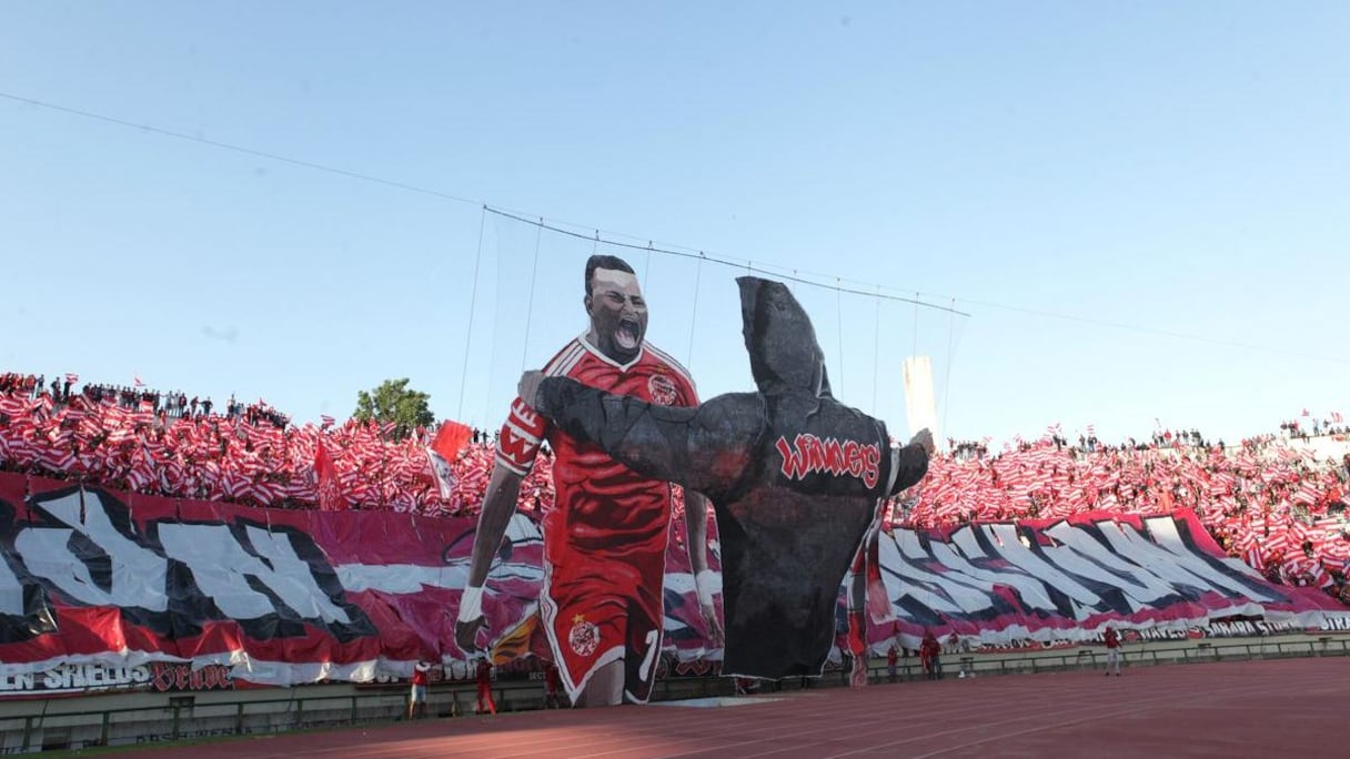 Encore un magnifique tifo 3D de la part du virage wydadi. Un supporter de dos fait face à Malick Evouna.