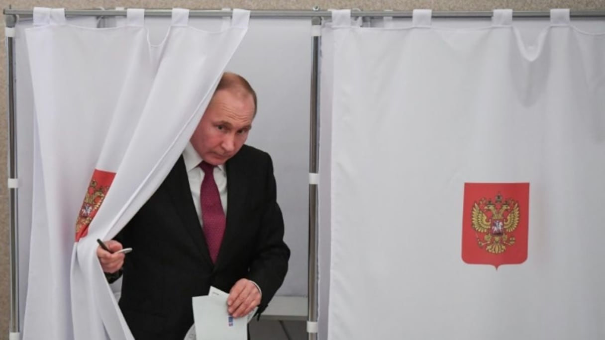 Vladimir Poutine sort d'un isoloir après avoir voté, le 18 mars 2018 à Moscou. 
