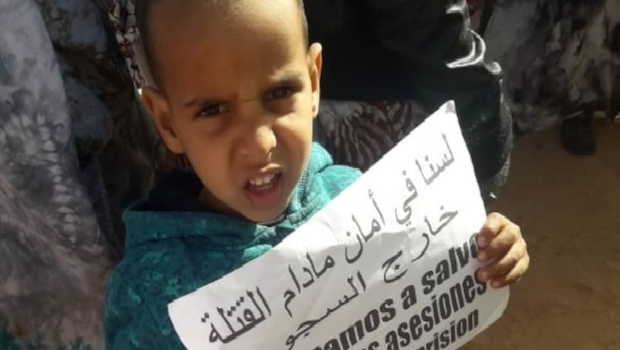 "Nous ne nous sentons pas en sécurité en présence des assassins qui courent librement", indique cette affiche arborée par un enfant. 
