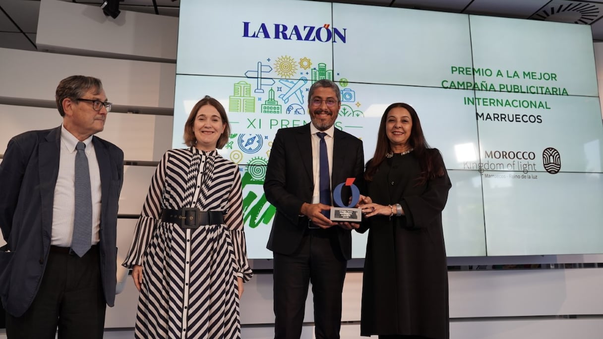 Adel El Fakir, directeur général de l'ONMT, reçoit le prix de meilleure campagne publicitaire internationale décerné par La Razon, aux côtés de Karima Benyaich, ambassadrice du Maroc en Espagne.
