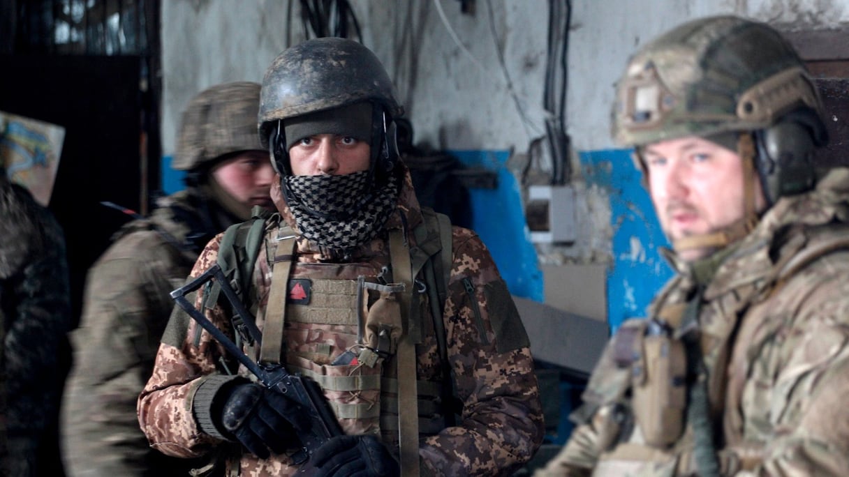 Des soldats des forces militaires ukrainiennes s'abritent lors d'un bombardement sur une position dans la région de Lougansk, le 5 mars 2022.
