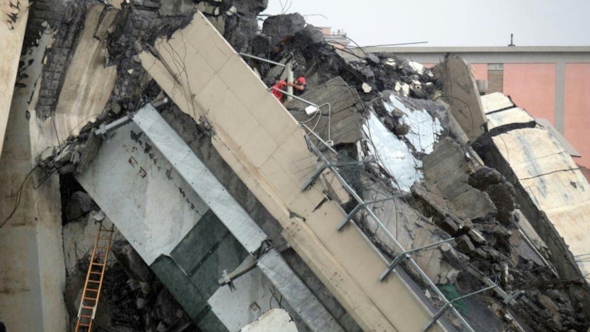 Sauveteurs sur une section du viaduc de l'A 10 à Gênes, dans le nord de l'Italie, le 14 août 2018 après son effondrement.
