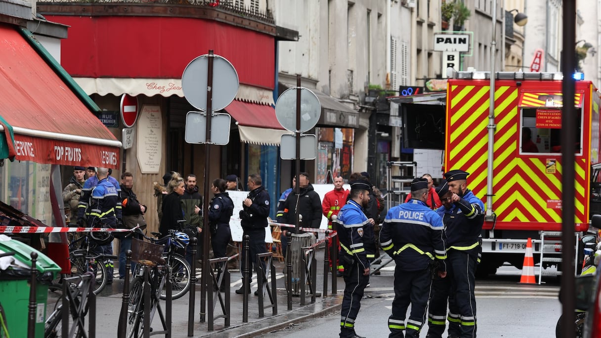 Le personnel de sécurité français sécurise la rue après que plusieurs coups de feu ont été tirés le long de la rue d'Enghien dans le 10e arrondissement, à Paris, le 23 décembre 2022. Deux personnes ont été tuées et quatre blessées.
