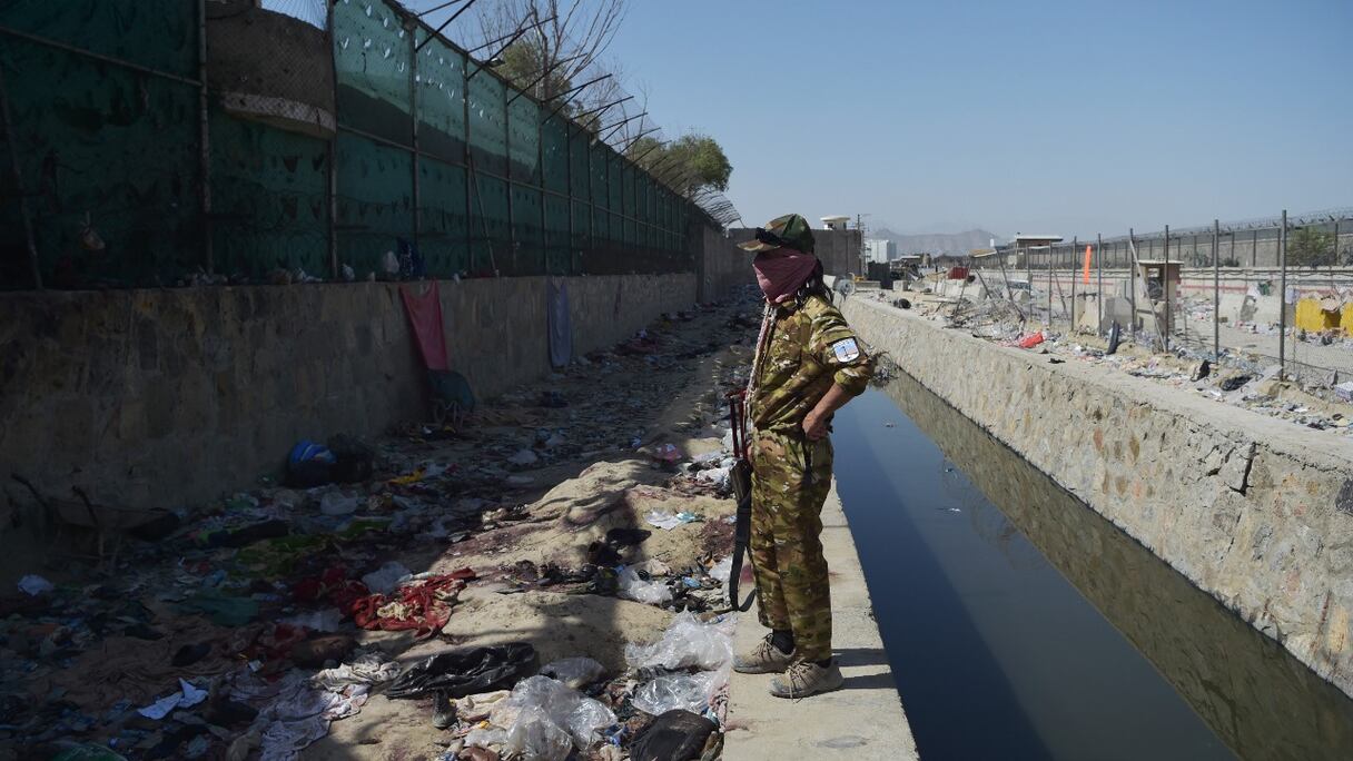 Un combattant taliban monte la garde sur le site des deux attentats suicides du 26 août, qui ont tué des dizaines de personnes, dont 13 soldats américains, à l'aéroport de Kaboul, le 27 août 2021.
