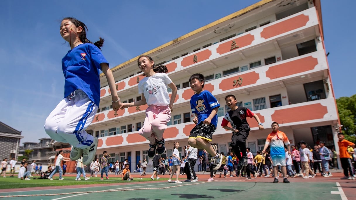 Des élèves de l'école primaire jouant lors de la Journée internationale des enfants à Haian, dans la province orientale du Jiangsu, en Chine, le 1er juin 2021, un jour après que la Chine a annoncé qu'elle autoriserait les couples à avoir trois enfants. 
