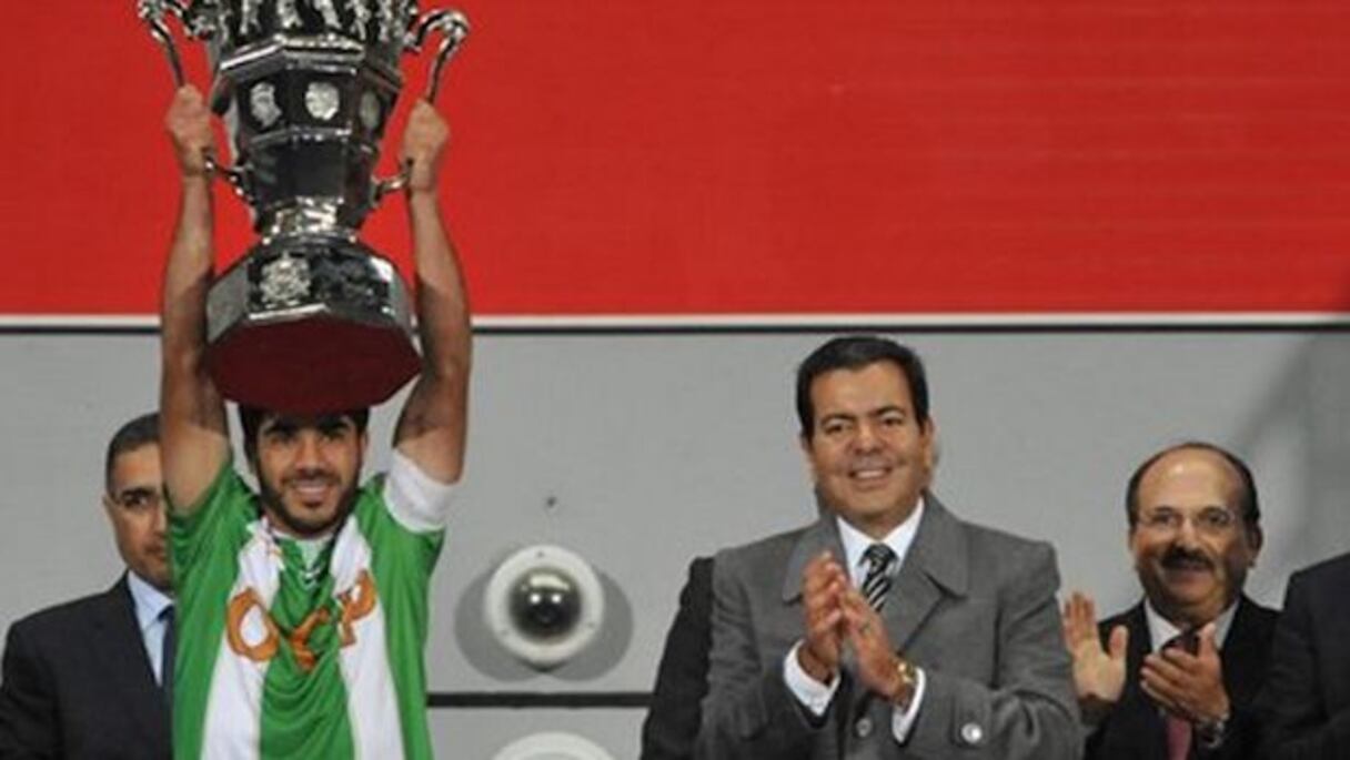 Le capitaine de l'OCK brandissant la Coupe du trône sous l'applaudissement du prince Moulay Rachid, mercredi 18 novembre au Grand Stade de Tanger.
