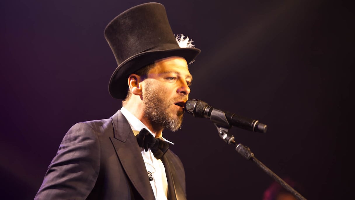 Costume noir, noeud papillon, chapeau haut de forme légèrement penché. Le nouveau look de Christophe Maé est très jazzy.
