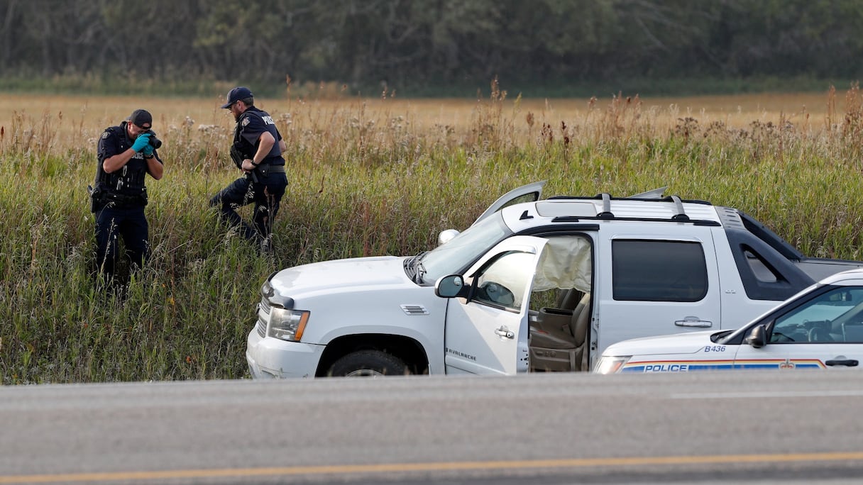 Des officiers de police canadiens prennent des photos sur la scène de l'arrestation du suspect Myles Sanderson, près de la ville de Rosthern, dans le Saskatchewan, le 7 septembre 2022.
