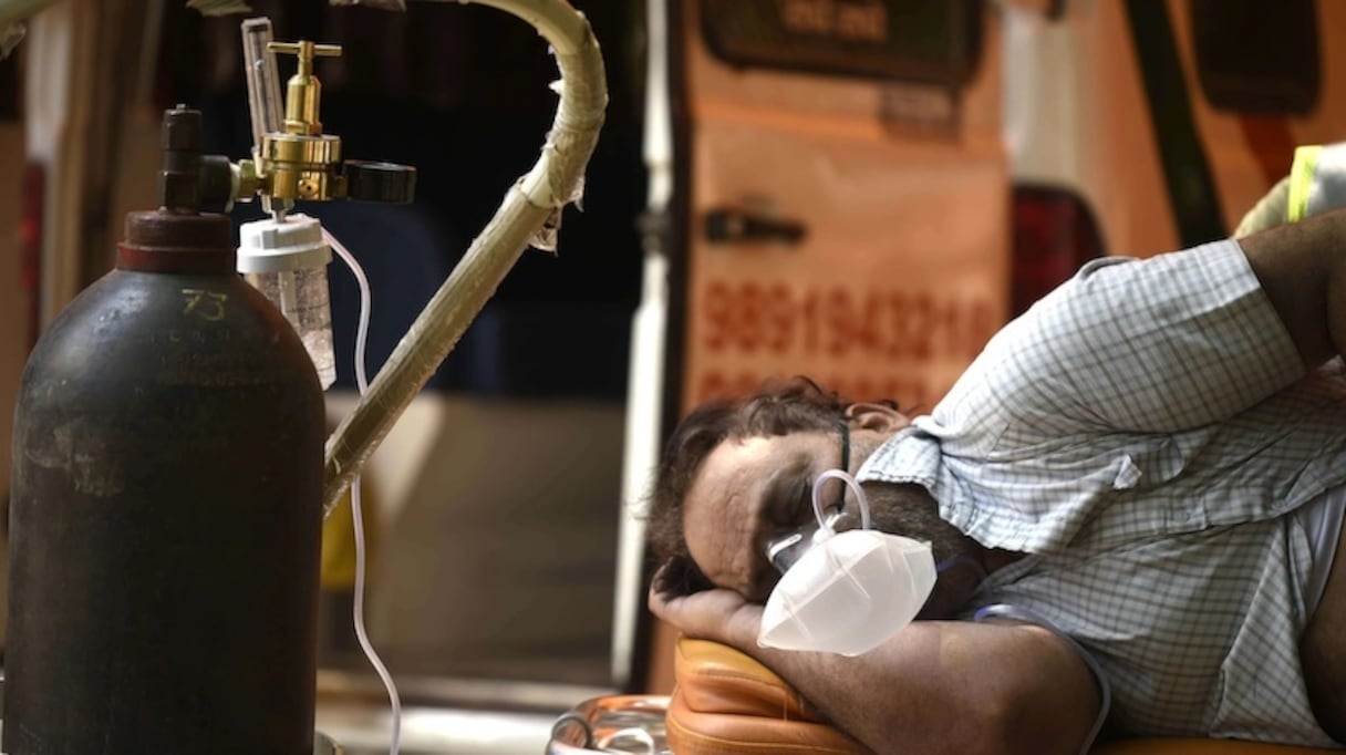 Patient atteint de Covid-19 respirant grâce à une bonbonne d'oxygène.
