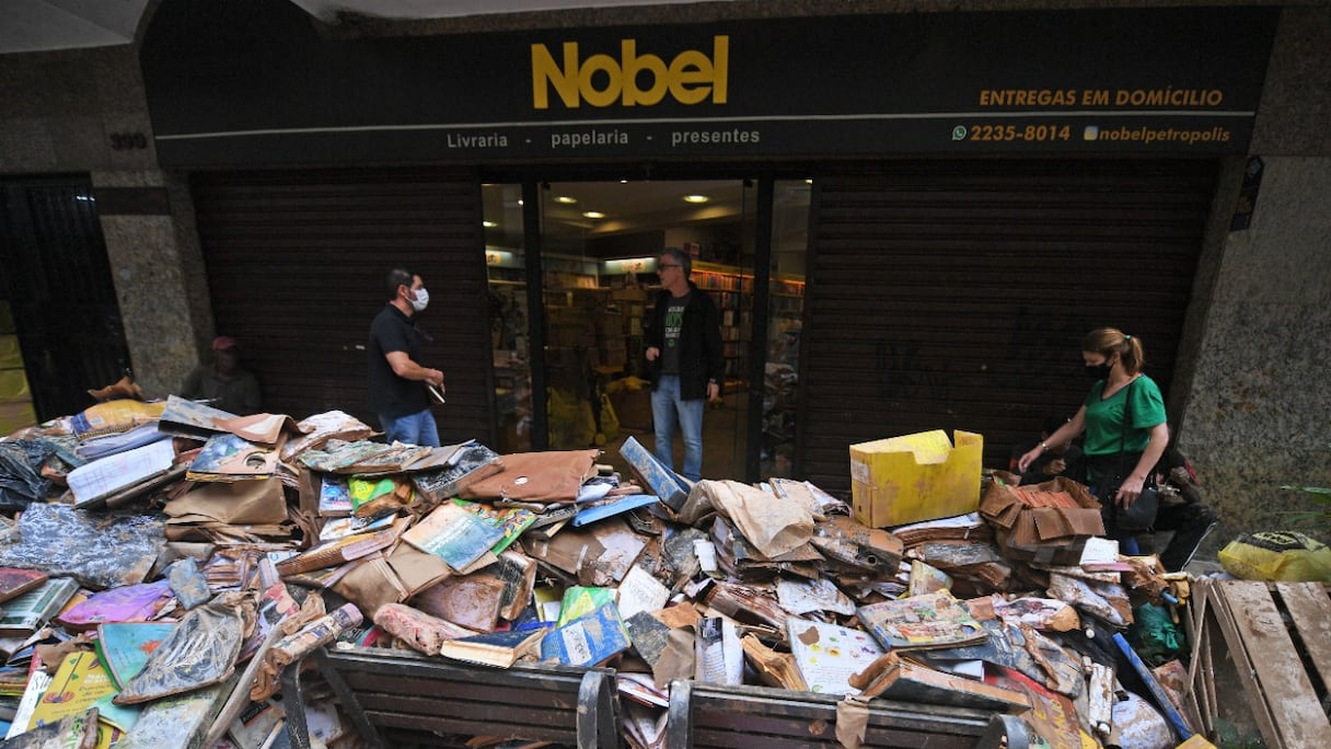 Des milliers de livres endommagés gisent dans la rue après de fortes pluies ayant inondé une librairie de Petropolis, au Brésil, le 19 février 2022. Un total de 165 corps ont été récupérés à ce jour, dans cette ville touristique à 60 km de Rio de Janeiro.
