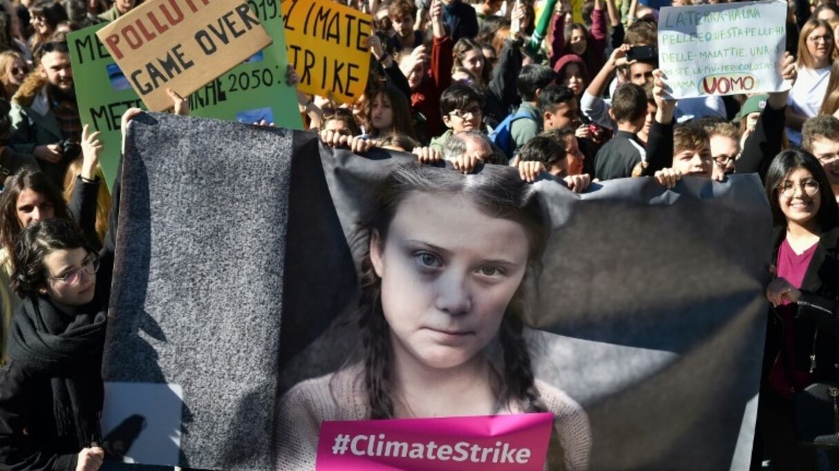 Des manifestants tiennent une banderole avec le portrait de l'activiste environnementale Greta Thunberg, à Rome le 15 mars 2019.

