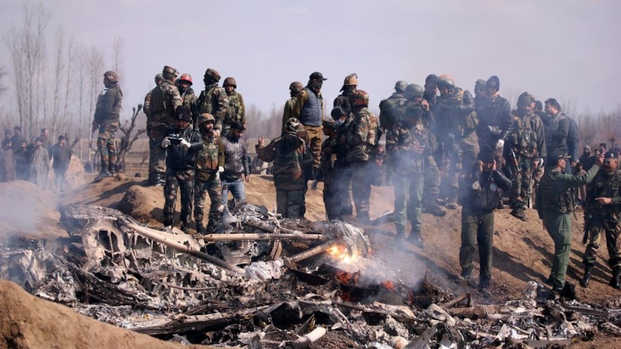 Des soldats pakistanais se tiennent devant les débris d'un hélicoptère de l'Indian Air Force détruit dans le district de Budgam, le 27 février 2019.
