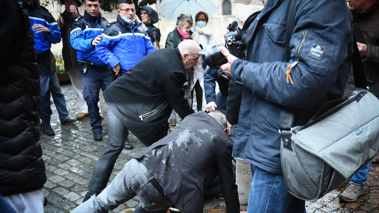 Un homme est arrêté par des agents de sécurité et des gendarmes français après avoir jeté un œuf sur Eric Zemmour, lors d'une visite de campagne à Moissac, le 12 mars 2022.
