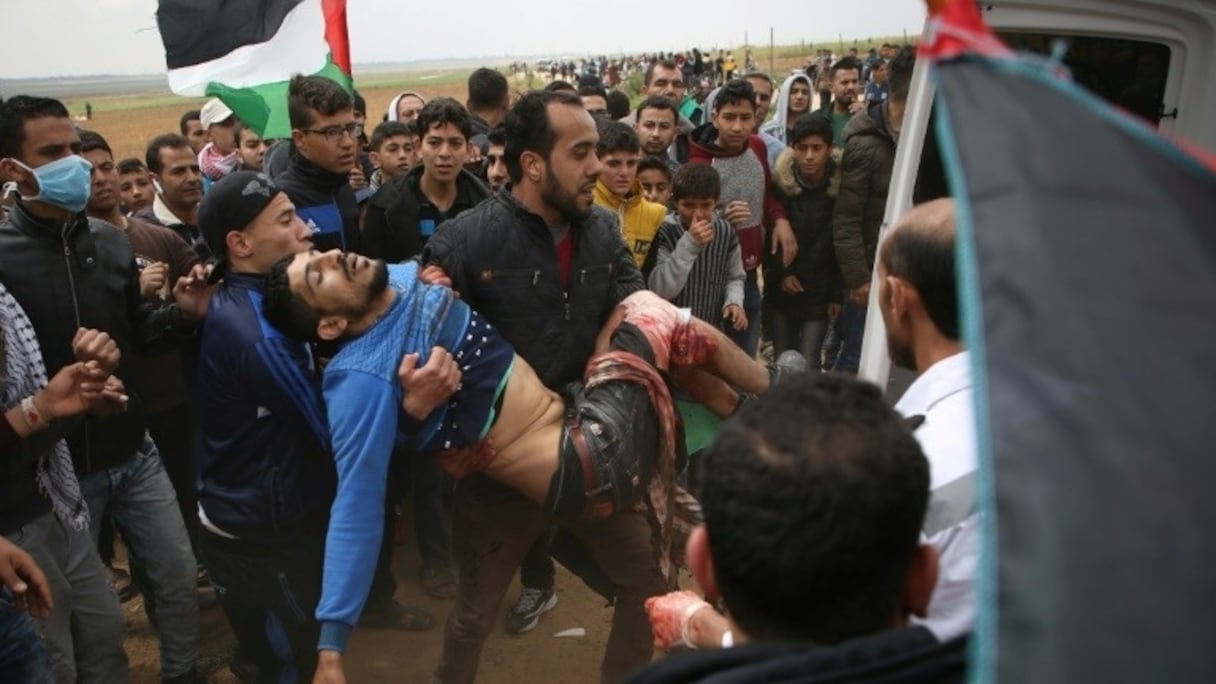 Un jeune Palestinien est porté dans une ambulance après avoir été blessé lors d'affrontements avec les forces israéliennes, le 30 mars 2018.
