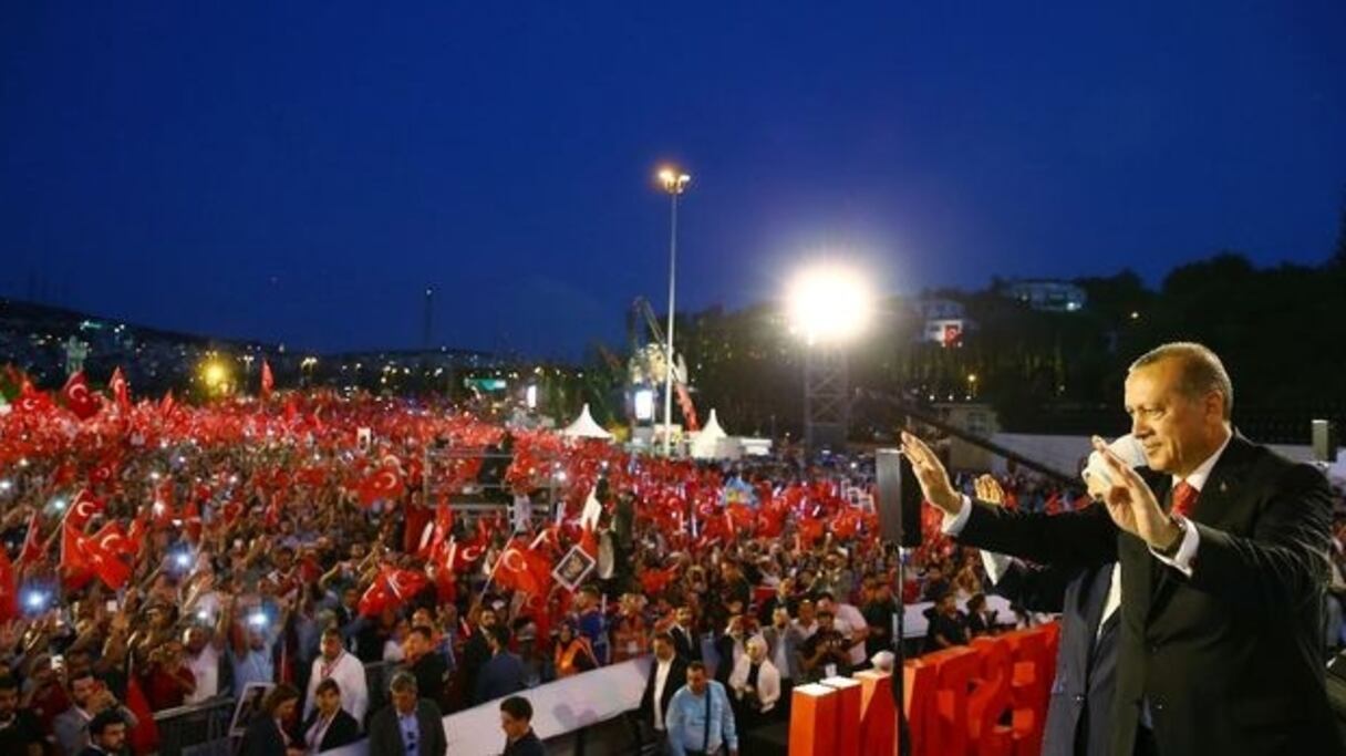 Le président turc Recep Tayyip Erdogan et sa femme Emine saluent la foule lors de la commémoration pour le premier anniversaire du putsch manqué, le 15 juillet 2017 à Istanbul.
