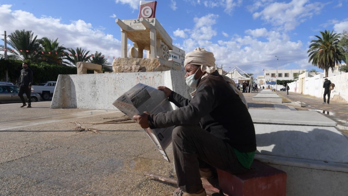 A Sidi Bouzid, centre de la Tunisie, un homme en masque de protection lisant le journal devant la statue dédiée à Mohamed Bouazizi, le marchand ambulant mort en 2011.
