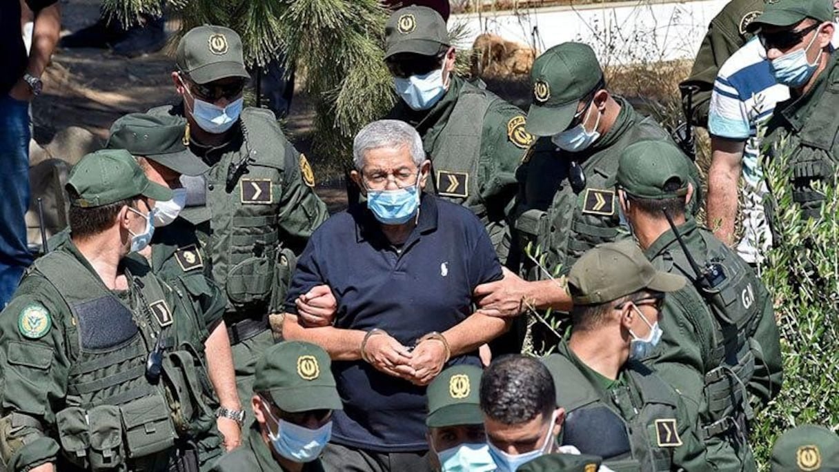 L'ancien Premier ministre algérien, Ahmed Ouyahia, menotté et sous haute surveillance dans un cimetière d'Alger, à l'enterrement de son frère, le 22 juin 2020.