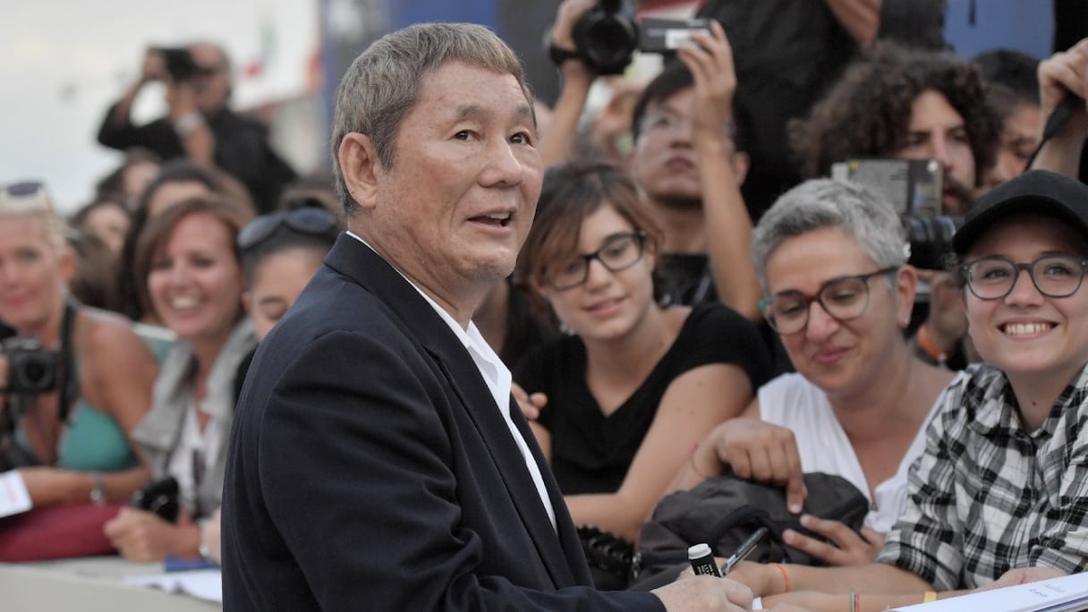 Le réalisateur japonais Takeshi Kitano signe des autographes à son arrivée à la projection de son film "Outrage Coda" à la 74e Mostra de Venise, le 9 septembre 2017.
