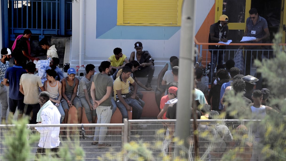 Des migrants se rassemblent dans une installation de traitement opérationnel de migrants dans l'île de Lampedusa, dans le sud de l'Italie, le 4 août 2022.
