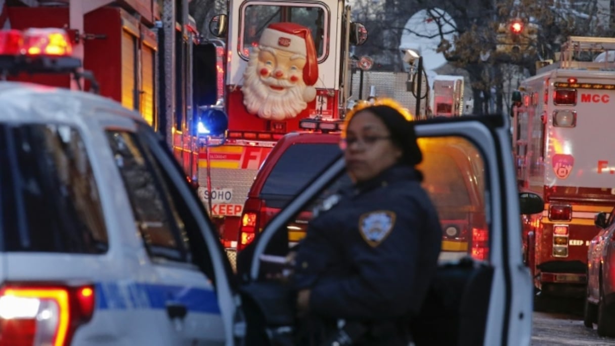 Une policière new-yorkaise le 29 décembre 2017 devant l'immeuble du Bronx où 12 personnes ont été tuées par un incendie la veille.
