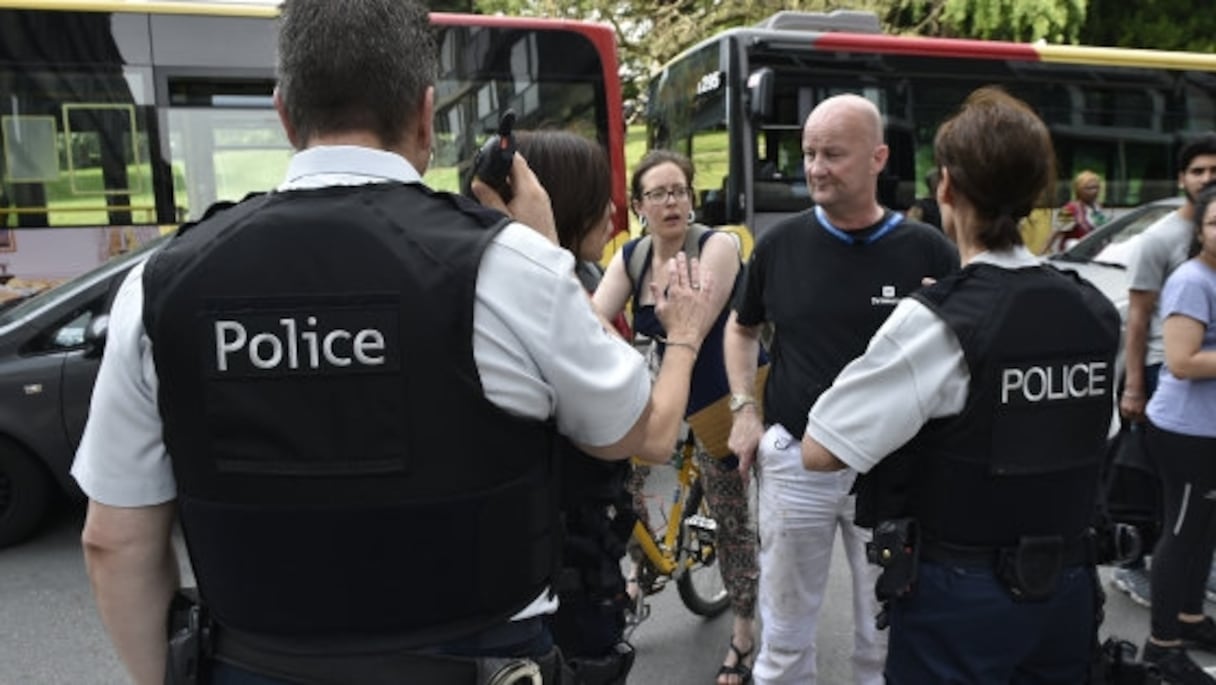 Des policiers parlent aux parents d'enfants scolarisés près des lieux de l'attaque à Liège, le 29 mai.
