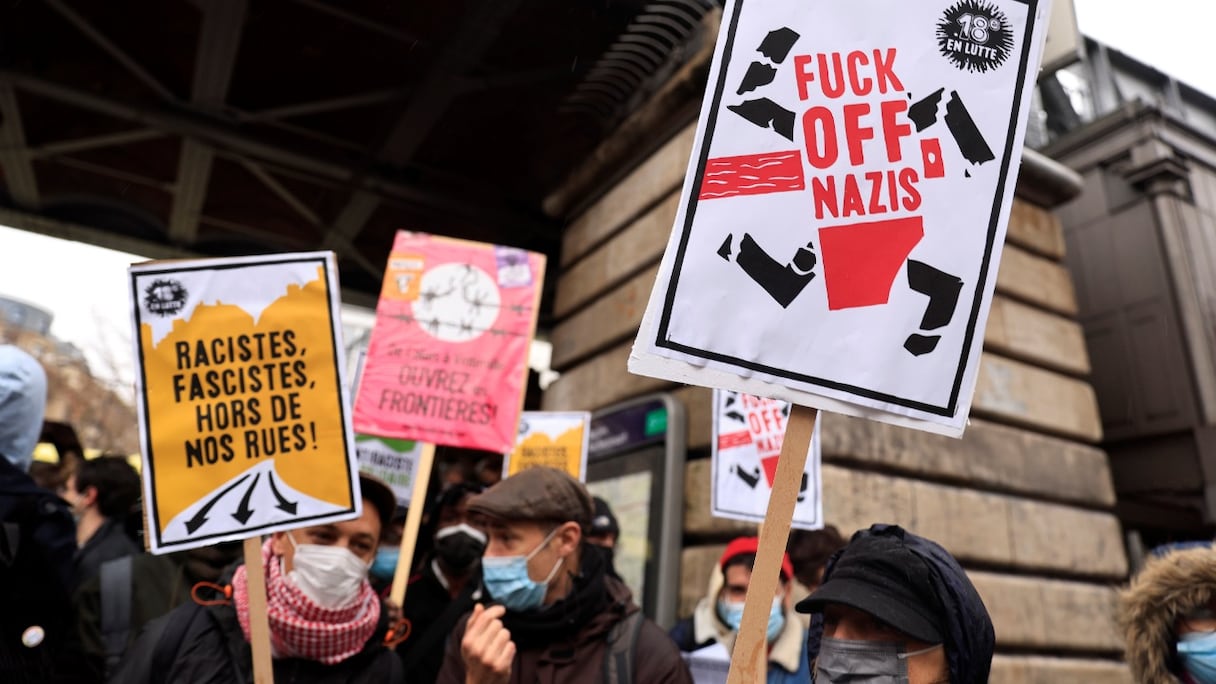 Des manifestants brandissent des pancartes lors d'un rassemblement pour protester contre le candidat d'extrême-droite français à la présidentielle de 2022, Eric Zemmour, à Paris, le 5 décembre 2021, au jour de son premier meeting officiel de campagne.
