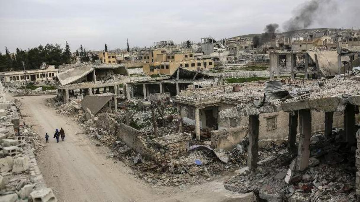 Des habitants marchent dans une rue dévastée de Kobané.
