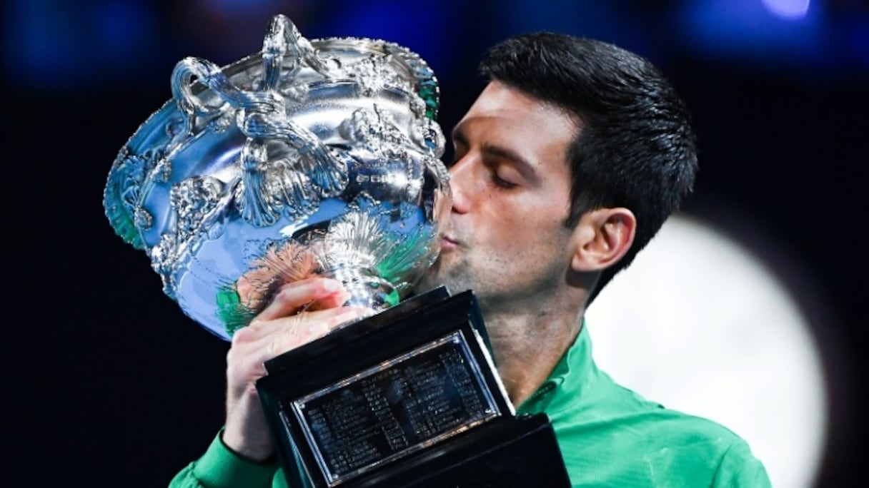 Novak Djokovic embrasse le trophée de l'Open d'Australie après sa victoire en finale à Melbourne contre Dominic Thiem le 3 février 2020
