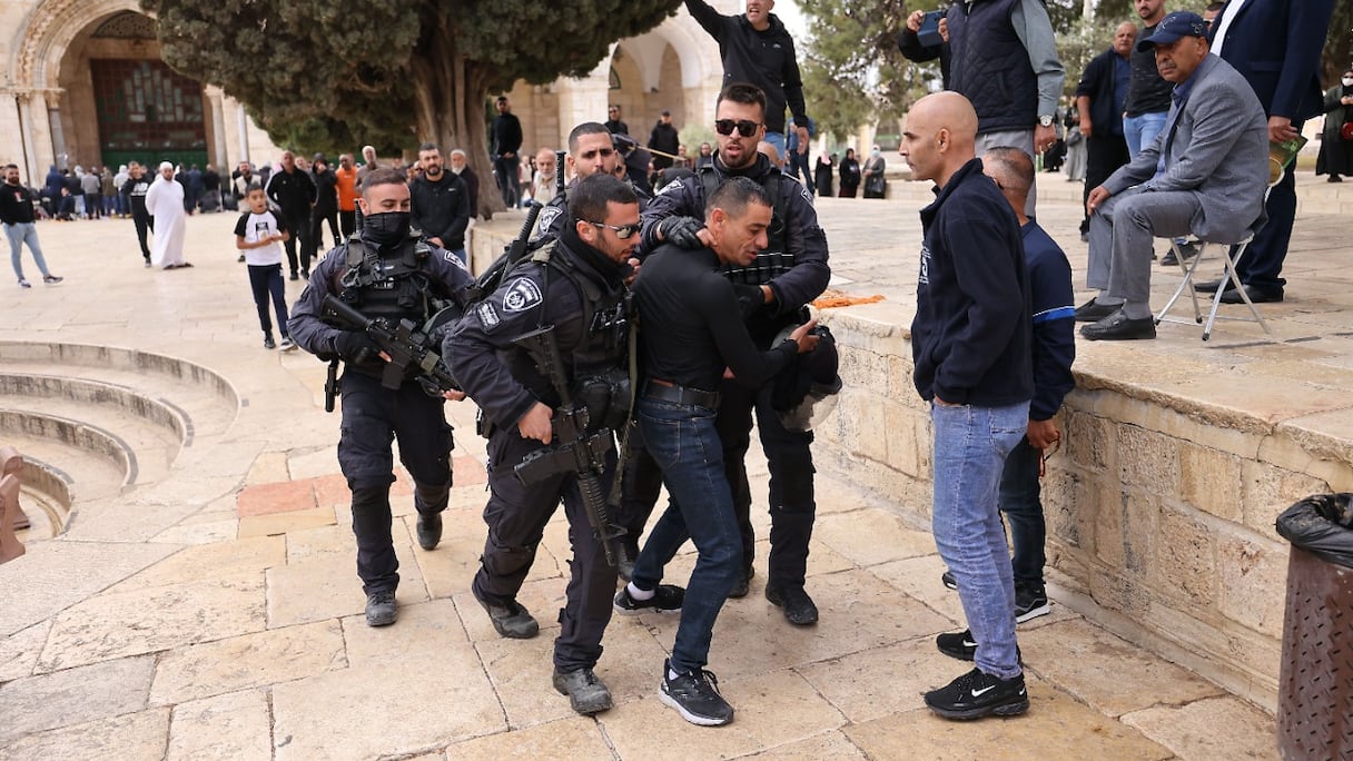 La police israélienne retient un manifestant palestinien alors que les forces de sécurité accompagnent un groupe de visiteurs juifs devant la mosquée du Dôme du Rocher dans l'enceinte de la mosquée al-Aqsa, dans la vieille ville de Jérusalem, le 5 mai 2022.
