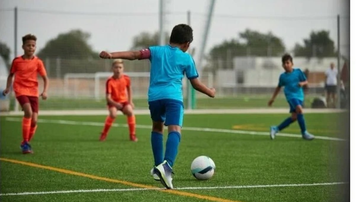 De jeunes enfants jouant au football sur un terrain synthétique (photo d'illustration).
