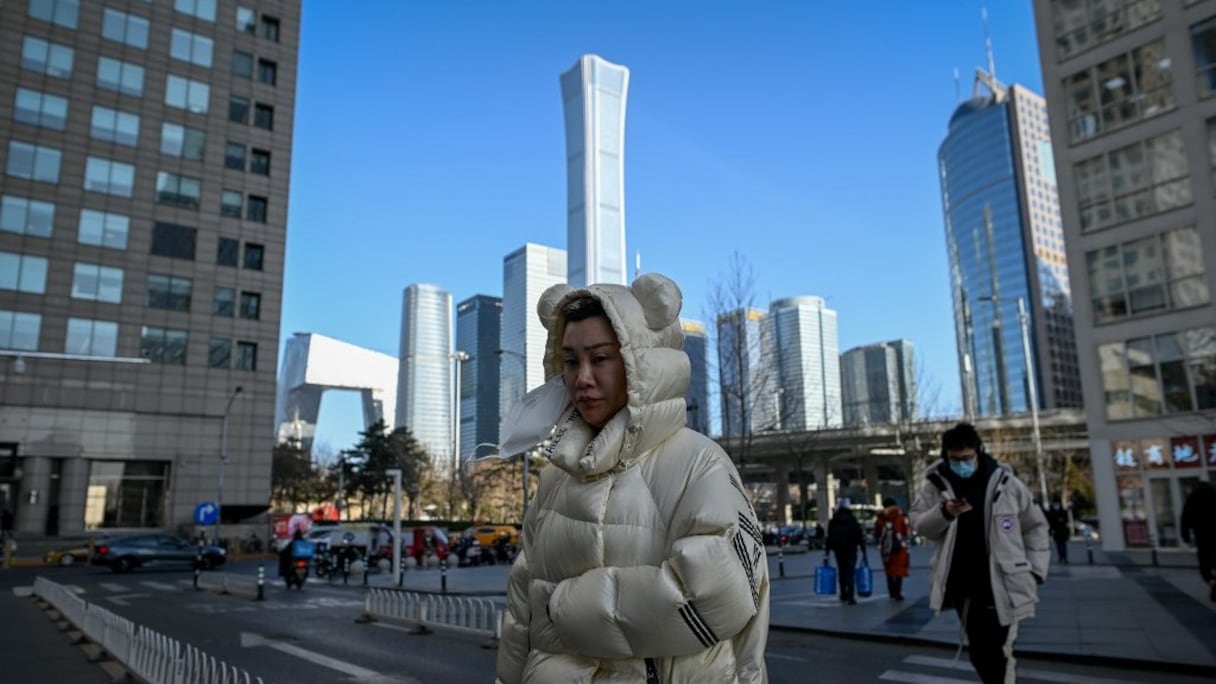 Des piétons traversent une avenue, dans le centre d'affaires de Pékin, le 18 janvier 2021. 
	 
