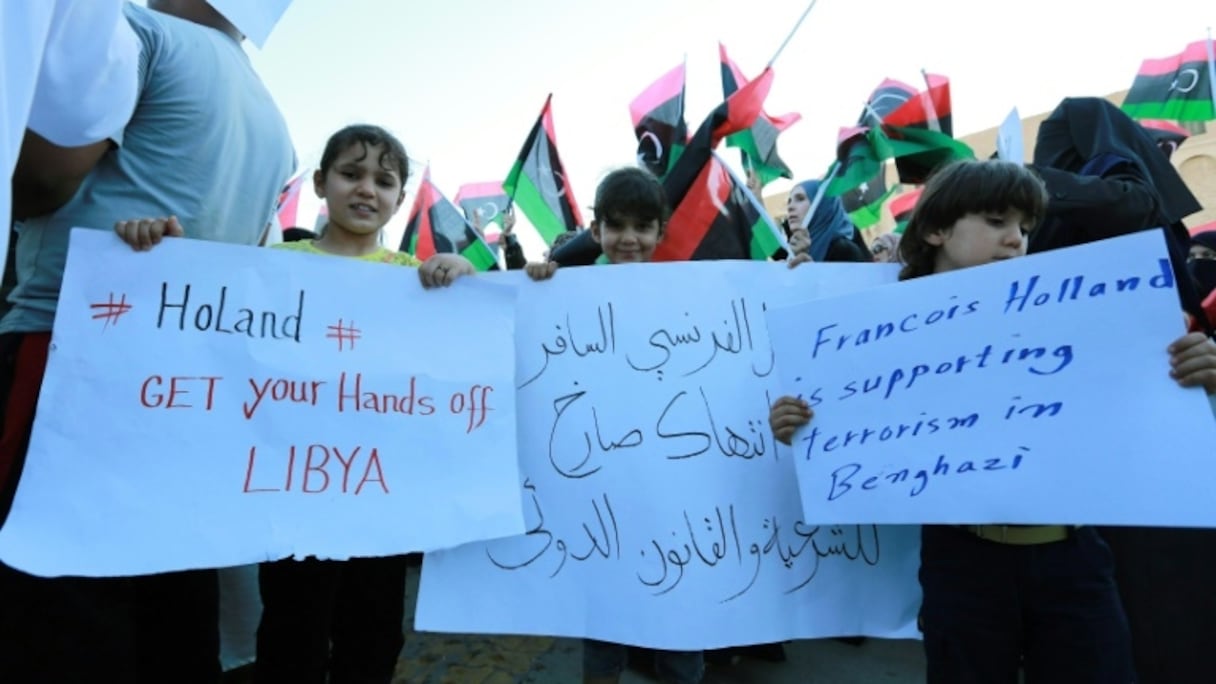 Des enfants libyens brandissent des pancartes pour dénoncer l'intervention militaire française dans leur pays, lors d'une manifestation à Tripoli le 20 juillet 2016.
