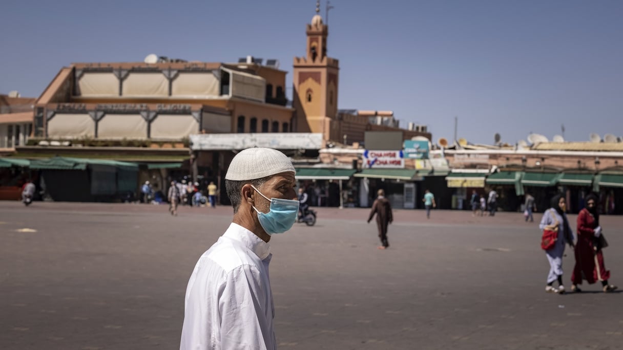 Peu de personnes marchent sur la place Jemaa el-Fna, à Marrakech, le 6 mai 2021. La ville est impactée par la crise du Covid-19 depuis son début en raison de la rareté des touristes. 
