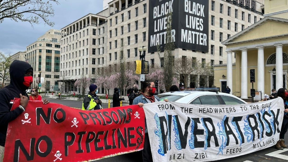 Des militants écologistes manifestent avec des banderoles, réclamant la fermeture d'oléoducs du nord des Etats-Unis, au Black Lives Matter Plaza à Washington, le 1er avril 2021.
