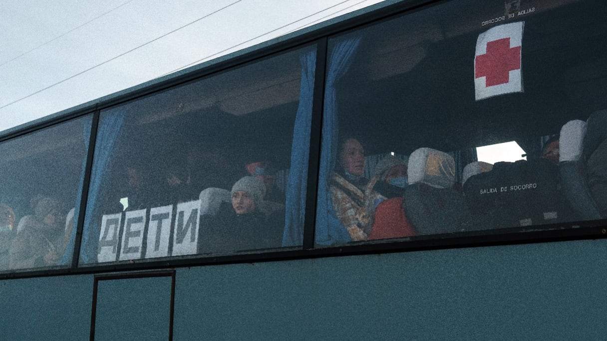 Des personnes sont assises dans un bus pendant que des agents enregistrent leur identité à un point d'évacuation à Zaporizhzhya, le 29 mars 2022, au milieu de l'invasion russe de l'Ukraine.
