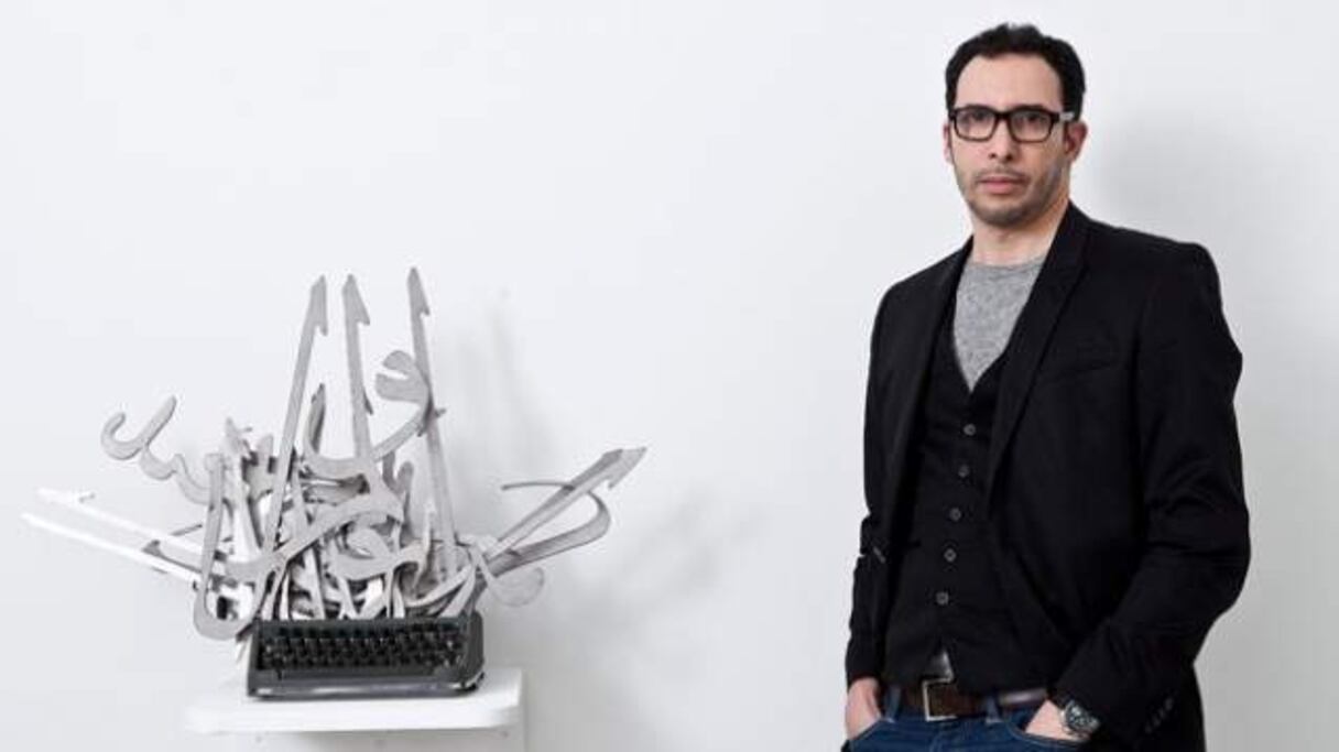 Mounir Fatmi et l'une de ses œuvres.
