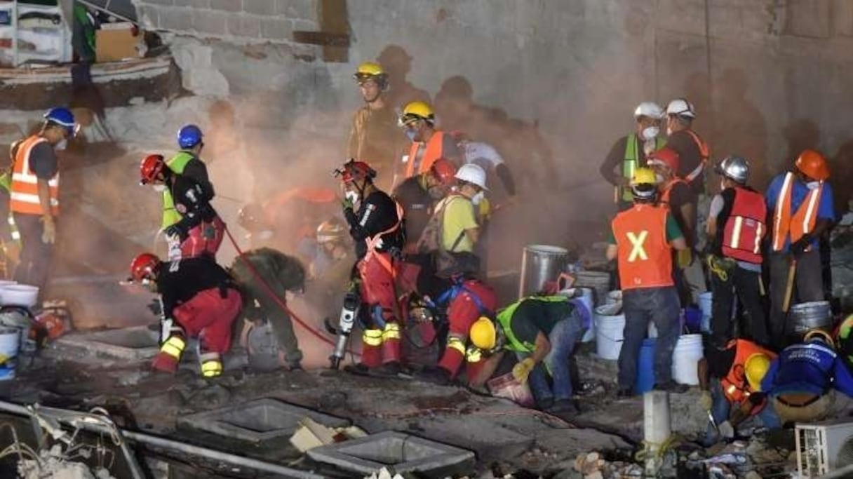 Des sauveteurs recherchent des survivants dans les décombres des immeubles.
