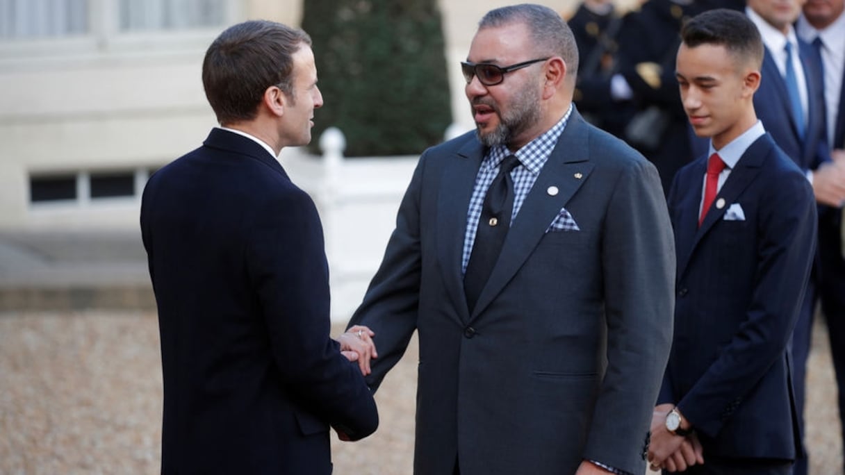 Le roi Mohammed VI saluant le président français Emmanuel Macron sous le regard du prince Moulay El Hassan lors du Sommet sur le climat en décembre 2017 à Paris.
