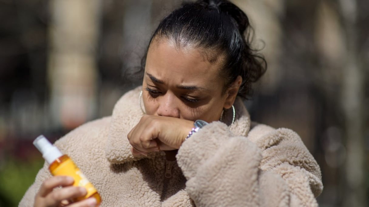 Elizabeth Medina, une conseillère d'orientation scolaire de 38 ans, sent sa main après avoir utilisé un désinfectant pour les mains lors d'un entretien avec l'AFP devant le New York-Presbyterian Hospital, le 22 mars 2021, à New York. 
