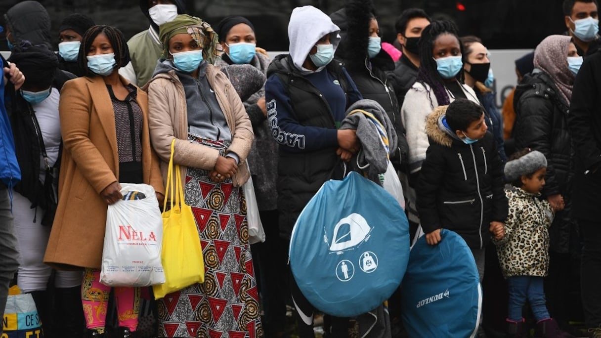 Des migrants attendent d'être évacués par la police française dans la banlieue nord de Paris, en Seine-Saint-Denis, le 17 novembre 2020. 
