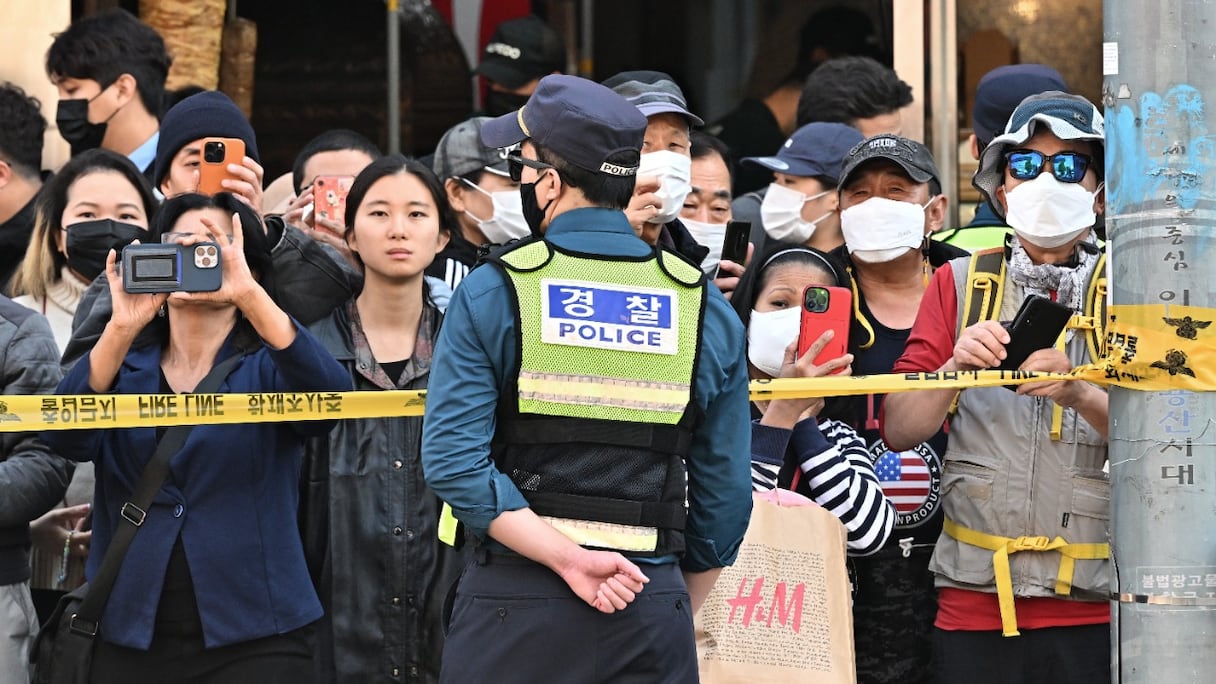 Un agent de la police sud-coréenne est posté devant un cordon de sécurité après une bousculade mortelle au cours d'une fête d'Halloween, le 29 octobre 2022 à Séoul. Plus de 150 personnes ont été tuées.
