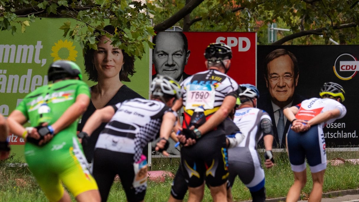 Au marathon de rollers de Berlin, les affiches électorales des trois candidats à la chancellerie aux élections fédérales du 26 septembre: la co-leader des Verts Annalena Baerbock, le ministre des Finances et vice-chancelier du SPD Olaf Scholz, et le chef de la CDU Armin Laschet, le 25 septembre 2021.
